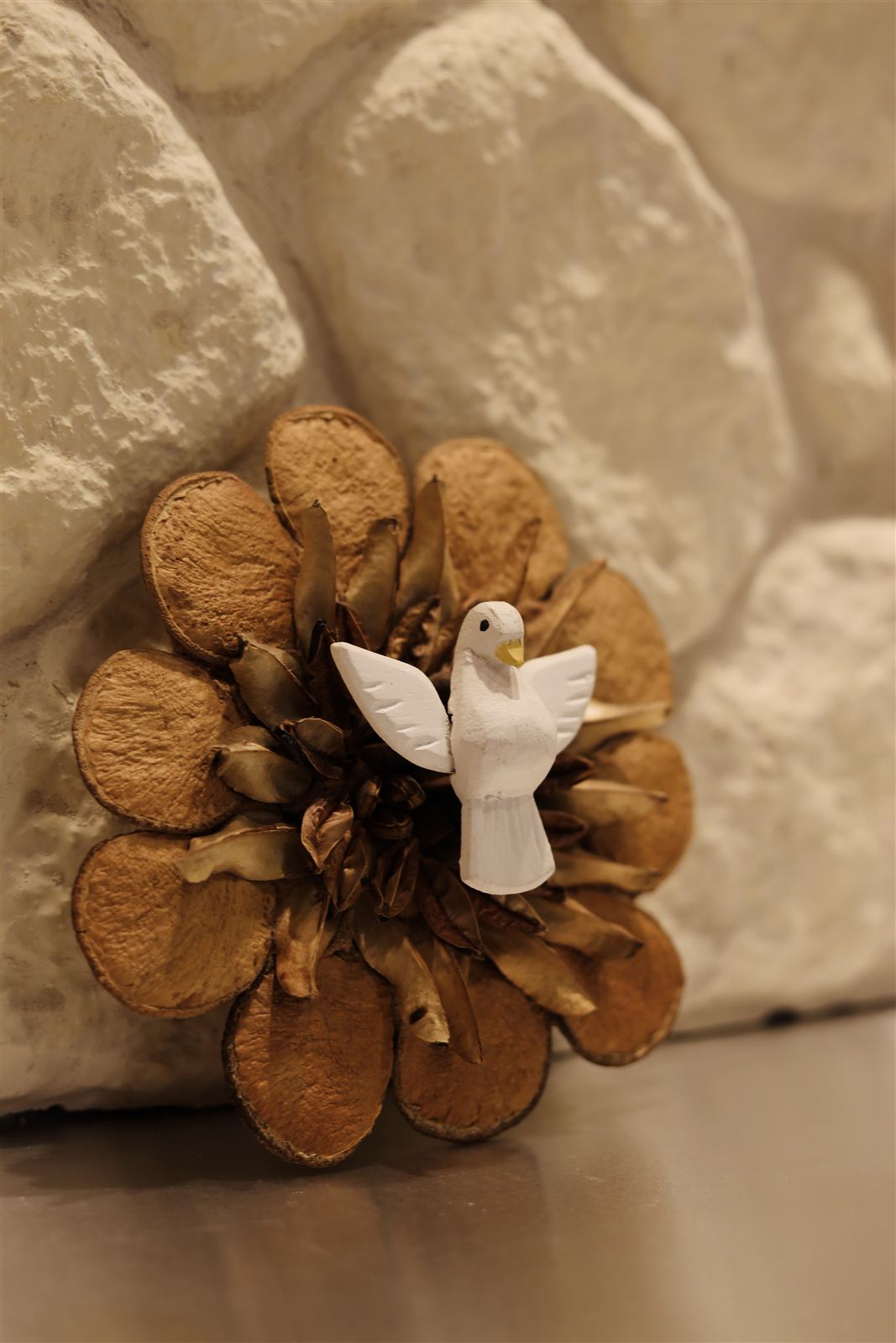 Detalhe de ornamento com pomba branca na parede de pedra