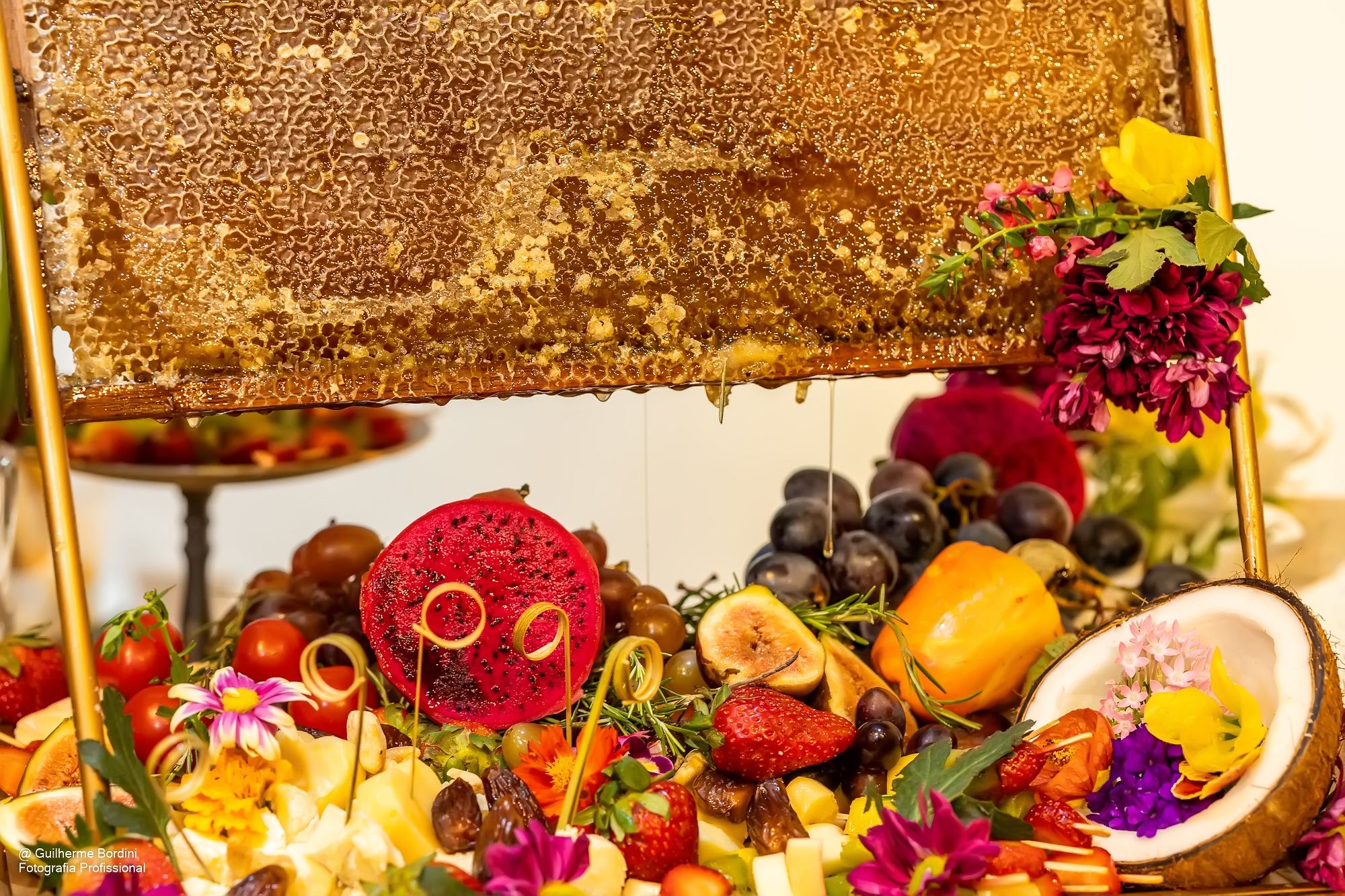 Mesa de coquetel com frutas, flores e favo de mel